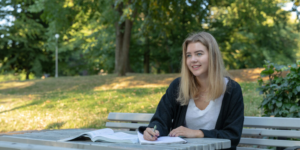 elev ute i en park söker till gymnasium